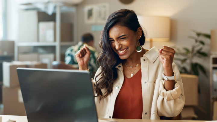 employee celebrating business win on laptop