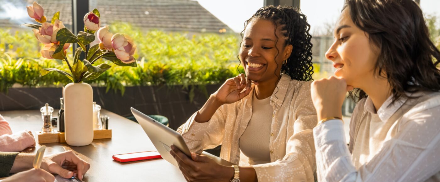 2 business professionals smiling at tablet screen celebrating