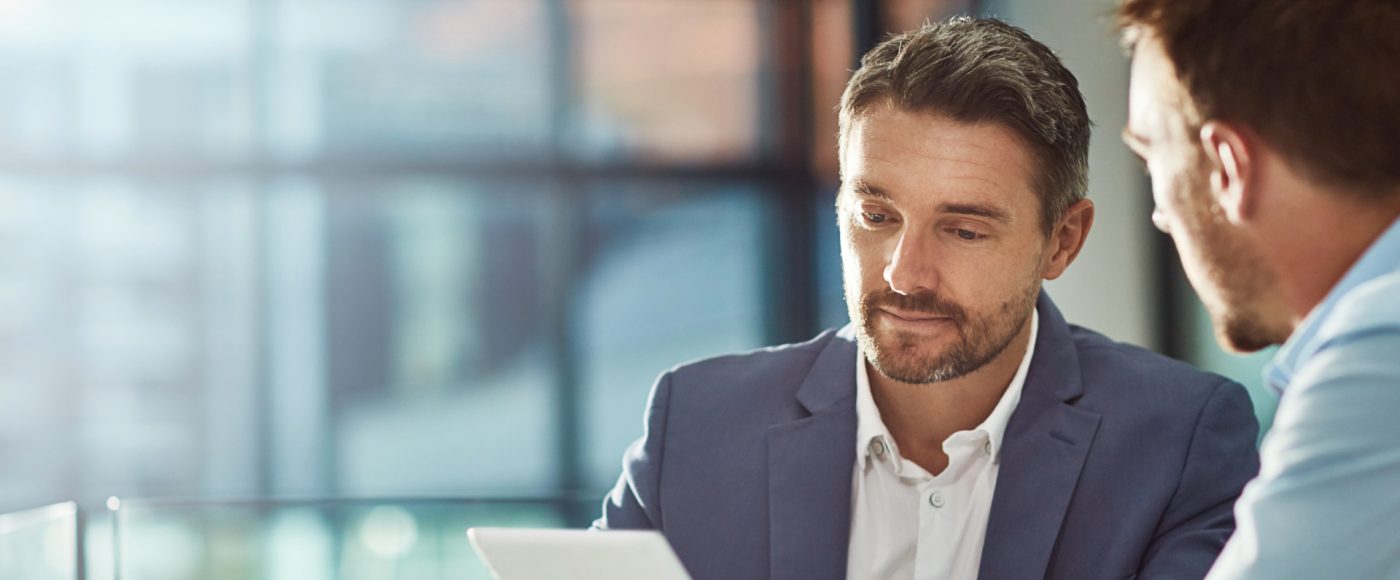 two business professionals working on laptop in bright modern office