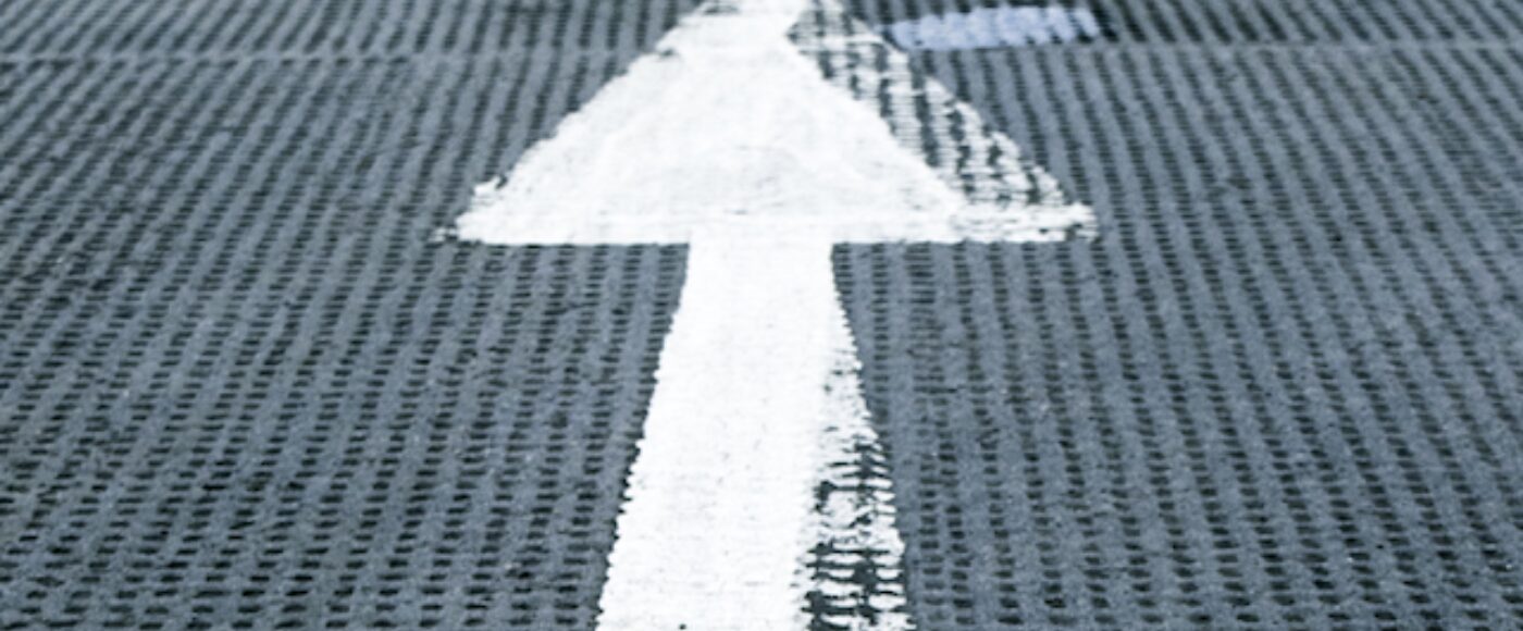 Image of small white arrow pointing up against a grey background