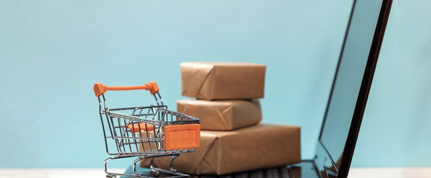 Laptop with miniature shopping card and brown packages