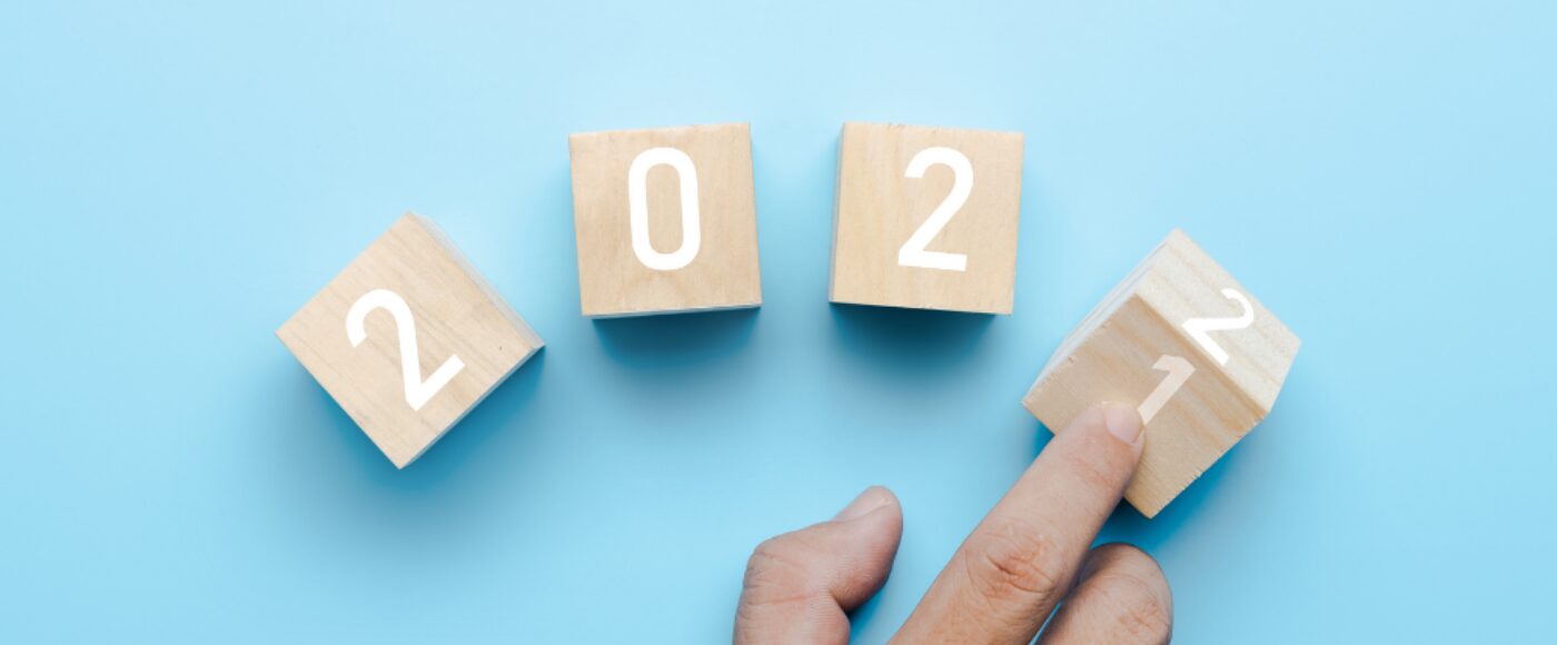 Hand of business people turn 2021 to 2022 on cube box