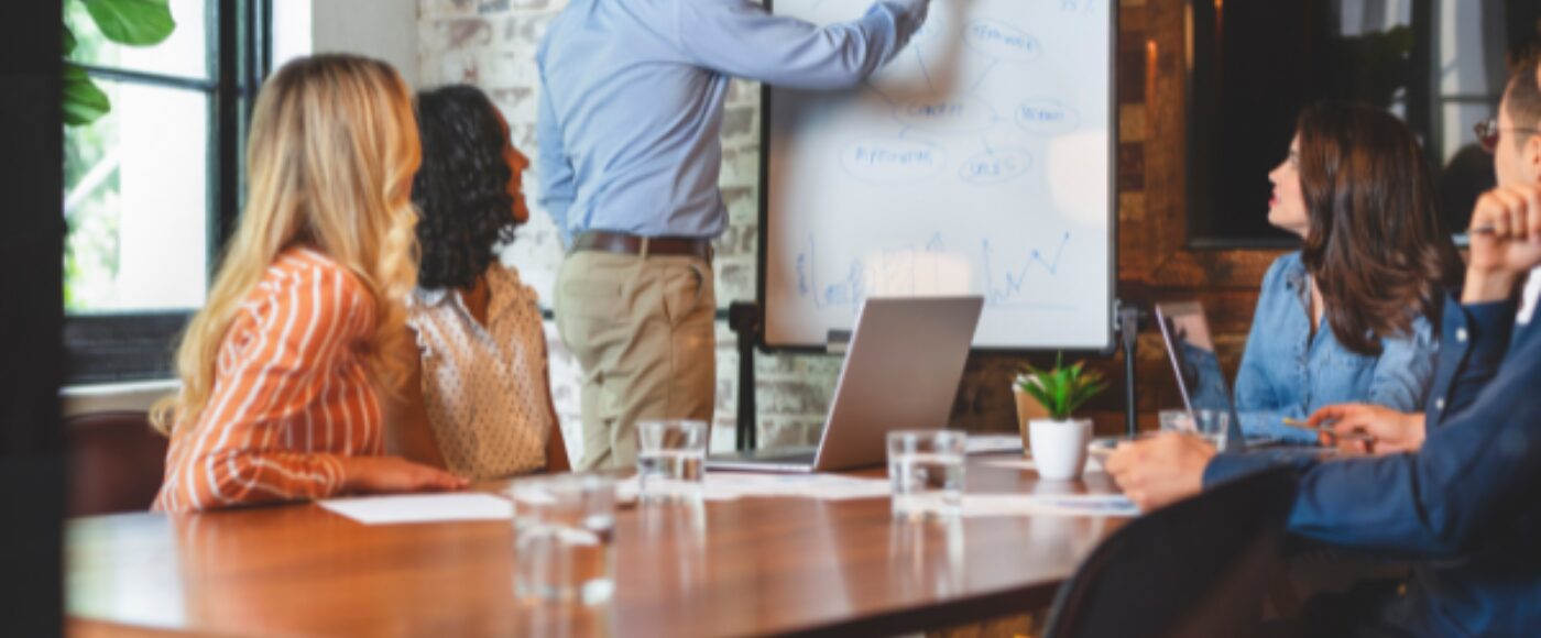 Office full of people watching a business presentation