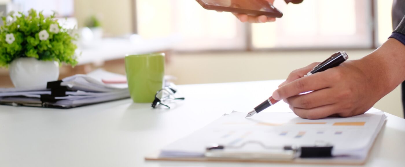 Businessman checklist on chart board paper working on table