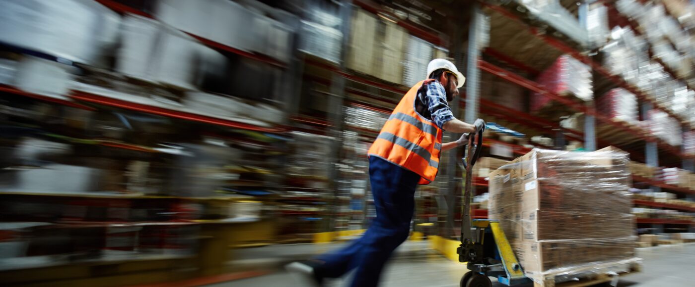 Factory worker pushing pallet trolley across factory floor v2