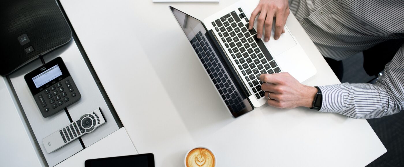 Person using laptop on white wooden table