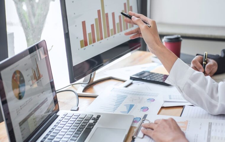 Business people looking at statistics on a computer screen.