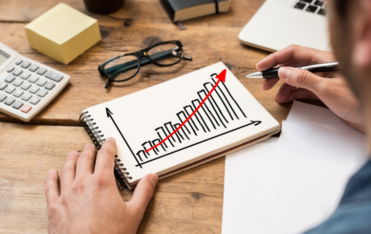 Businessman drawing a growing chart on a paper notebook